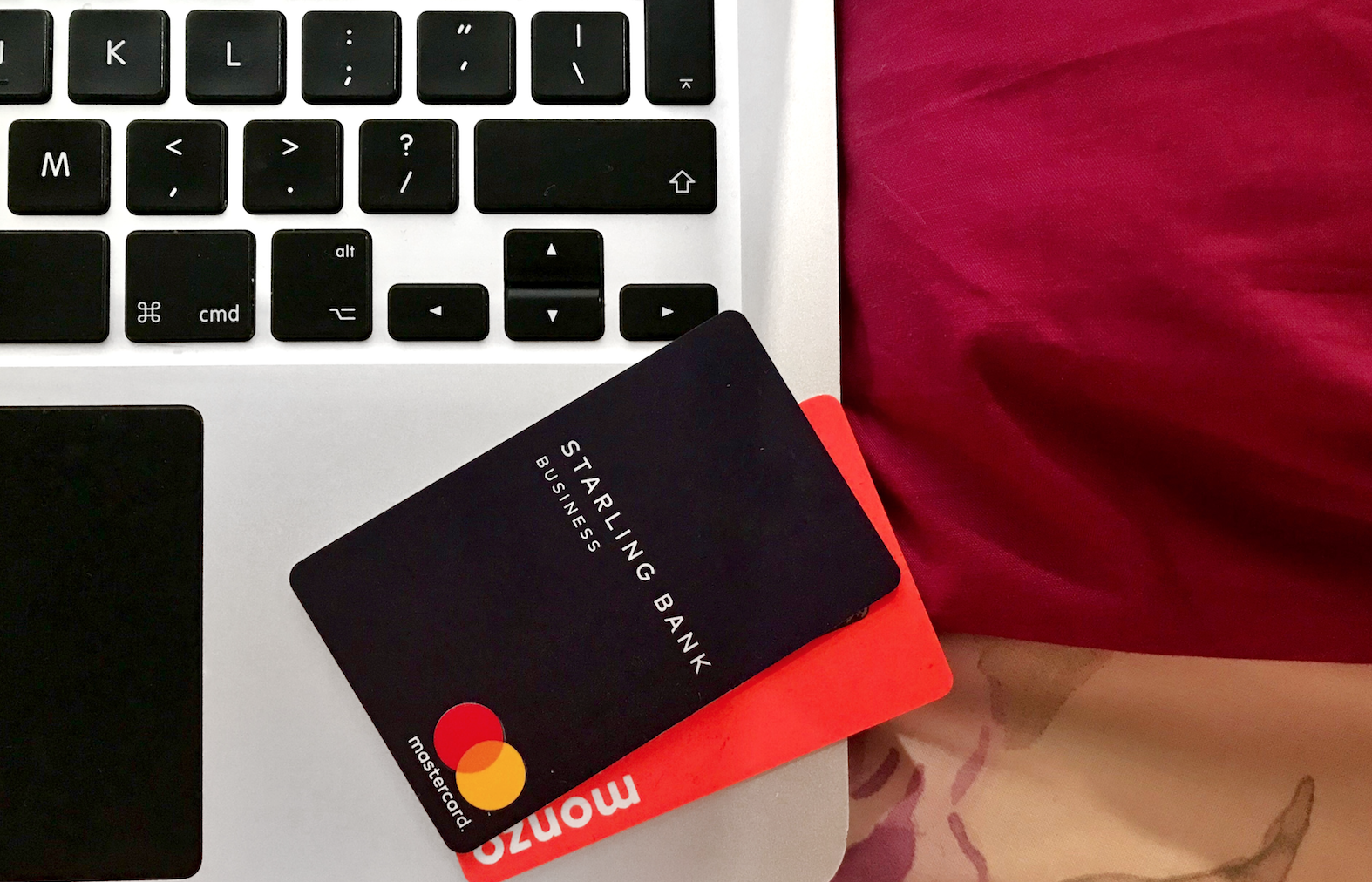 Photo of my Starling Business Bank and Monzo cards on my Macbook Pro